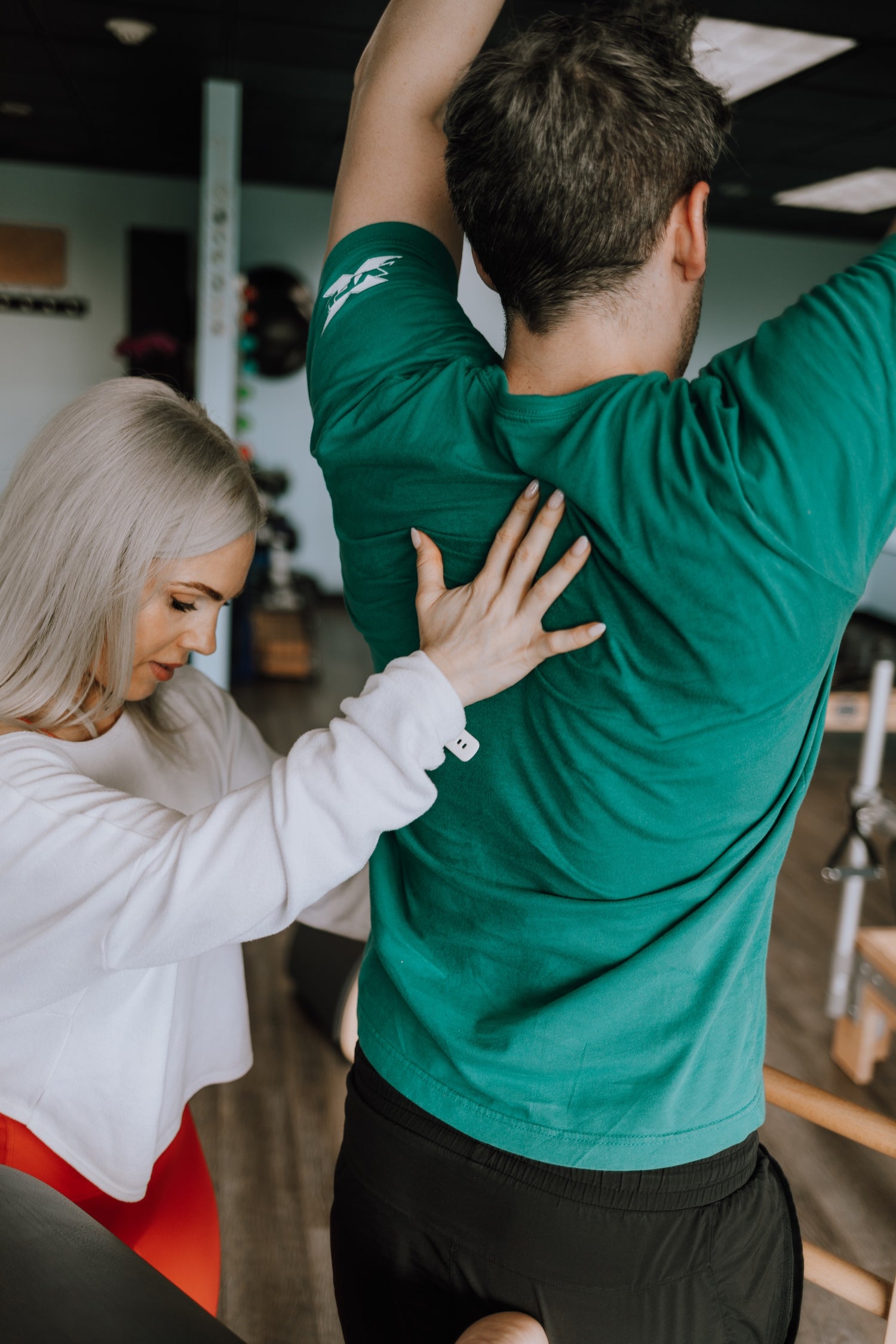 Pilates instructor helping a client 1-on-1 with corrections
