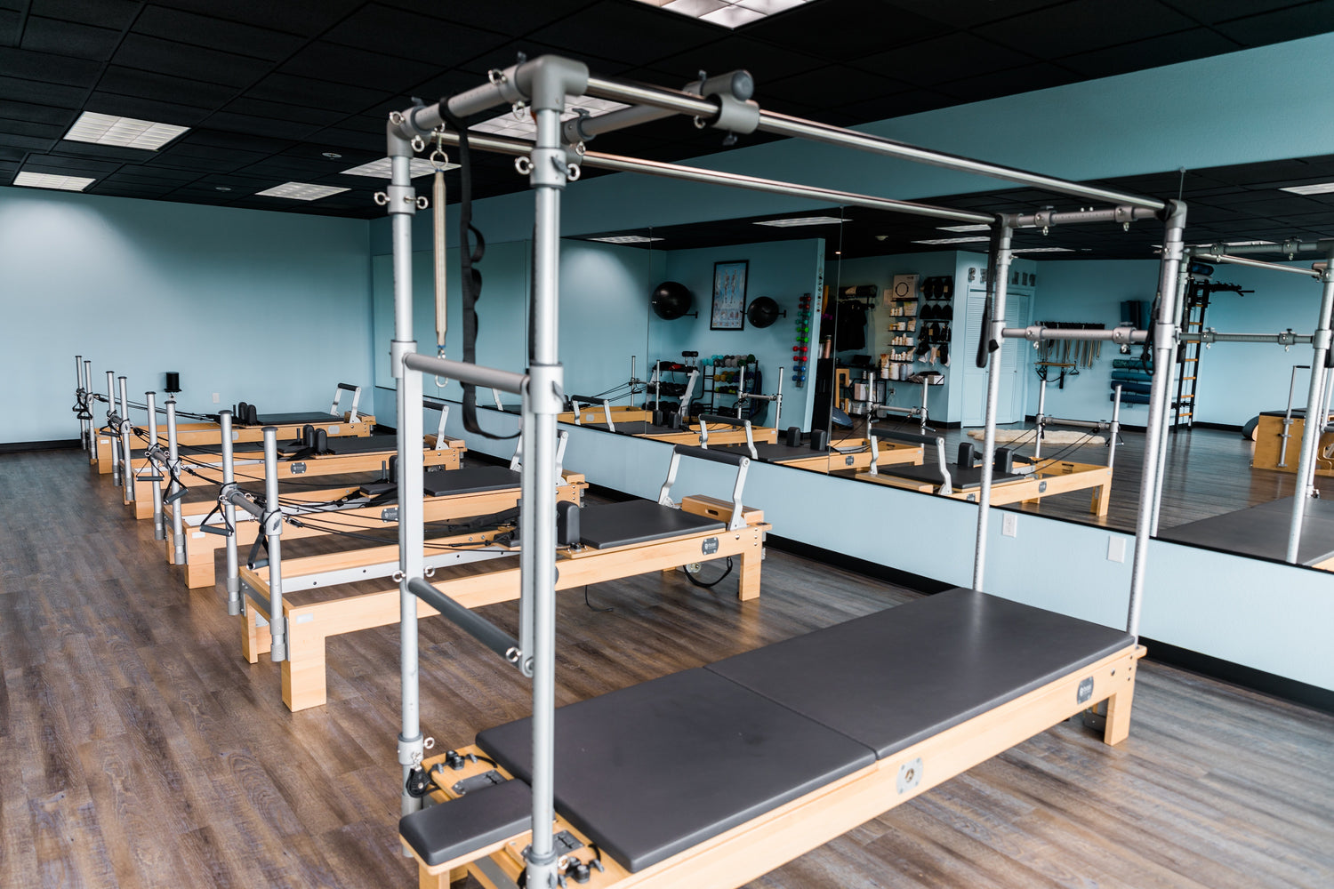 Pilates reformers in a studio with mirrors and equipment in the background