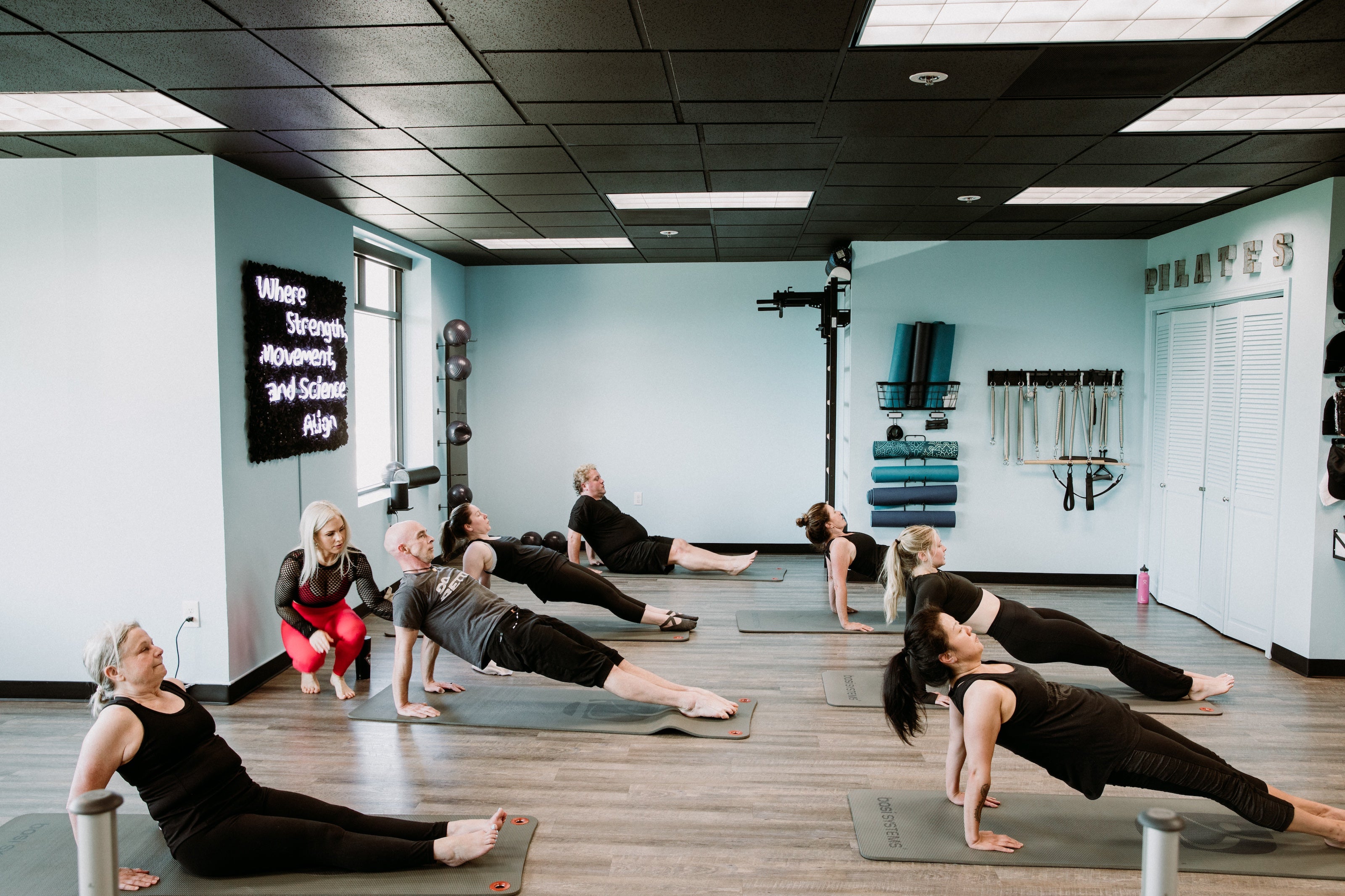 Pilates Instructor leading a mat pilates class