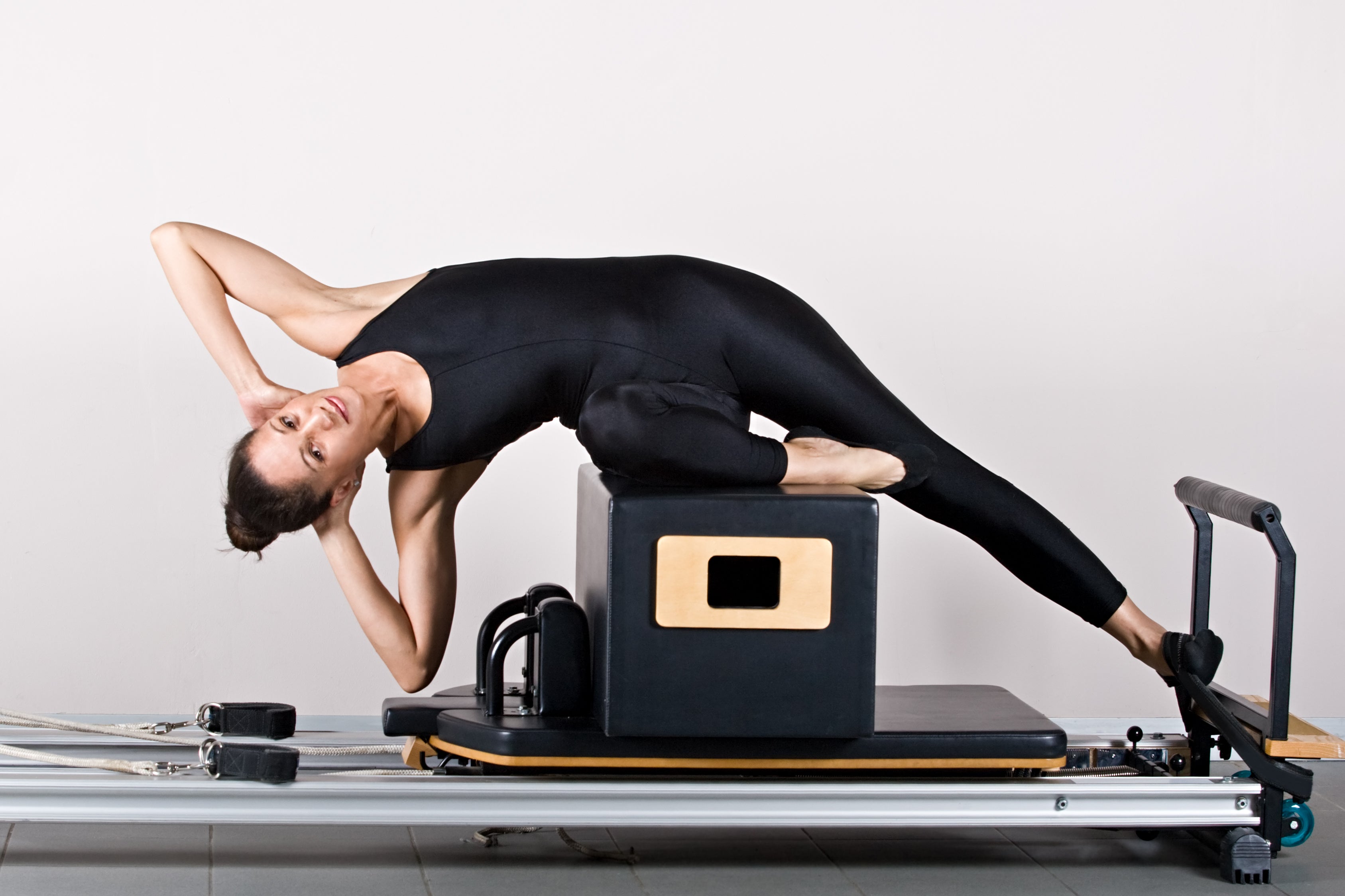 woman doing a side bend on a reformer