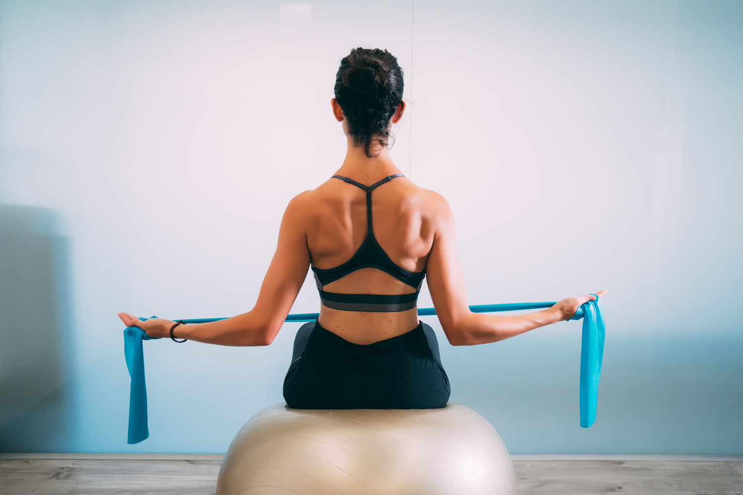 woman on exercise ball with band